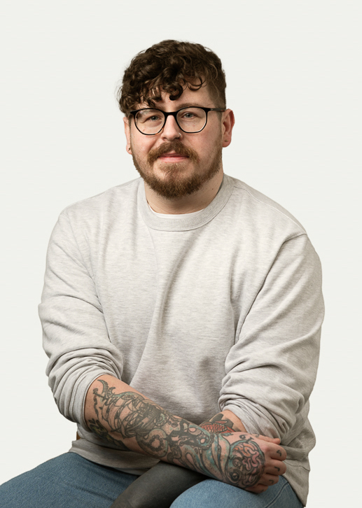 Profile shot of Scott Riley. Curly-haired lad wearing glasses and a white jumper poses earnestly for his school photograph.
